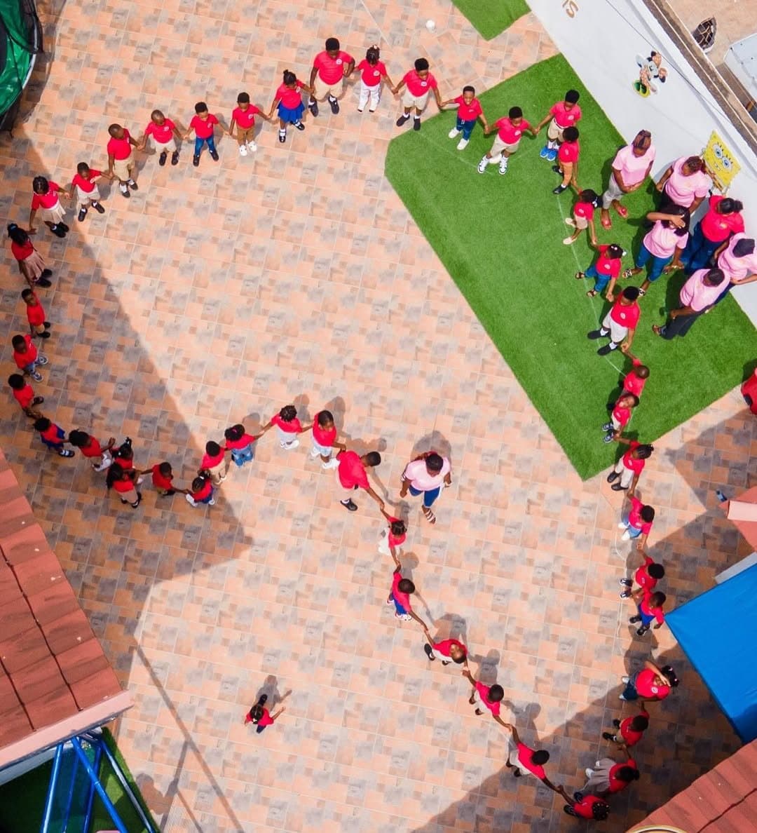 Aerial view of WWIS learners forming a heart in the playground