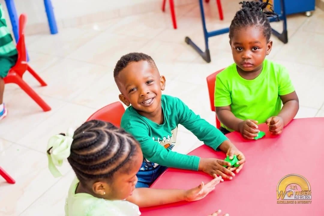 Toddlers playing with modelling clay at a red table