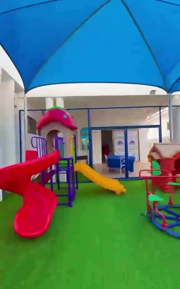 WWIS shaded playground with slides and artificial turf
